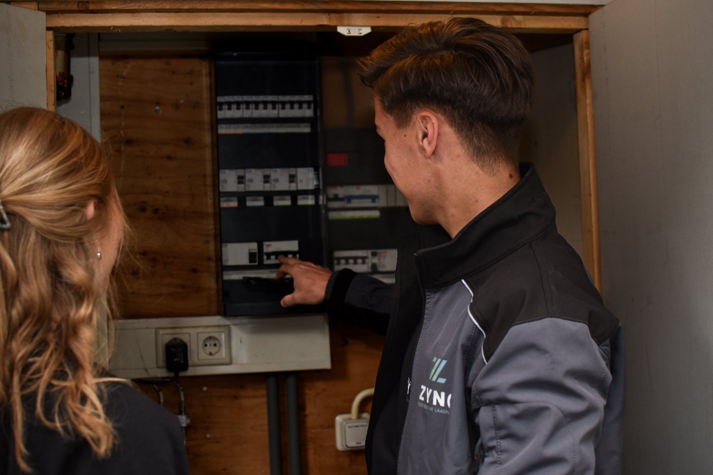 Installateur controleert groepenkast voor slimme laadpaal en energiebeheer